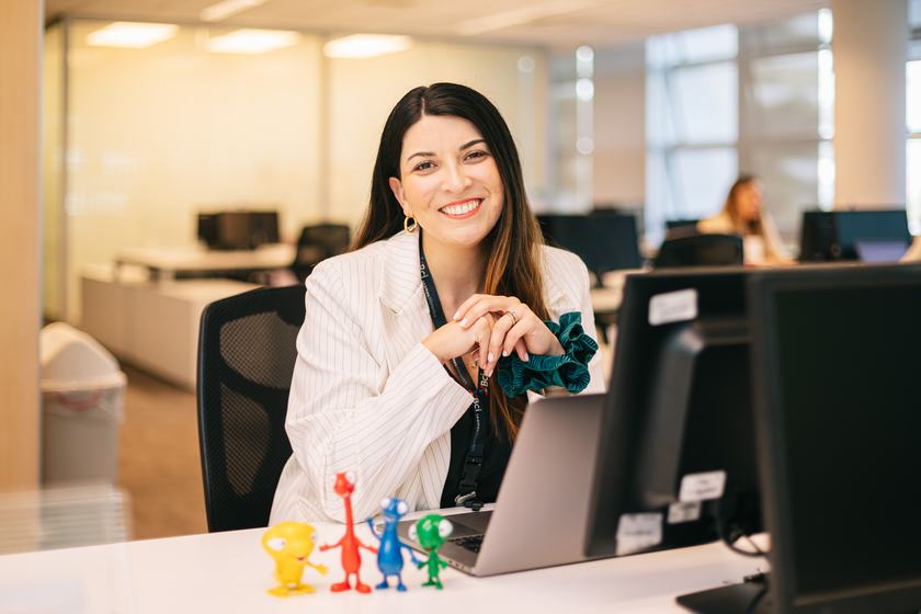 Colaboradora sonriendo en su puesto de trabajo